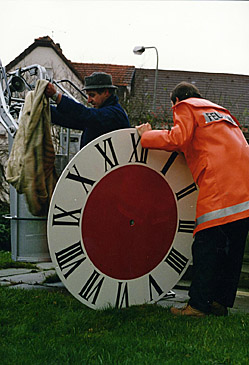 Auf dem Bild ist das Ziffernblatt zu sehen, bevor es mit Hilfe der Feuerwehrleiter am Kirchturm angebracht wurde.